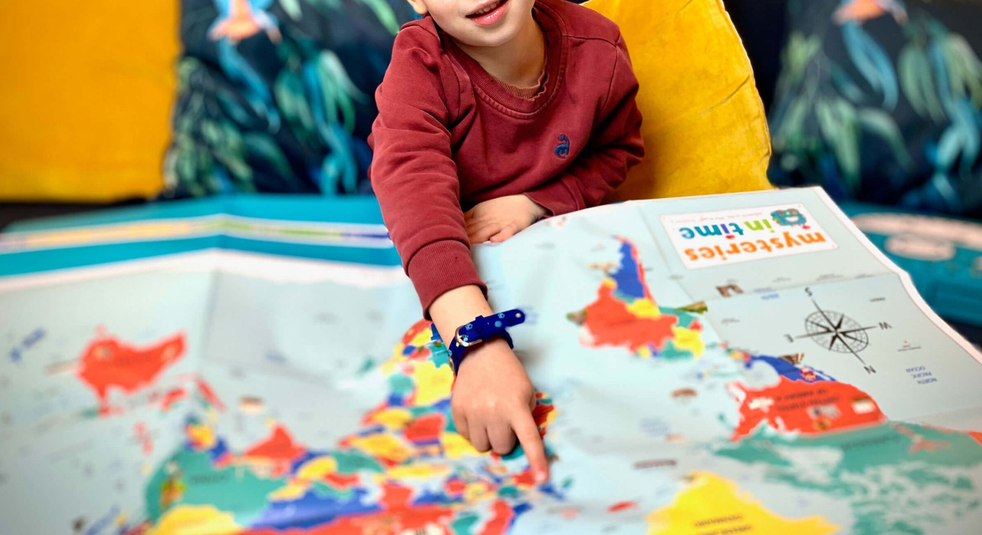 Child exploring a colourful Mysteries in Time world map