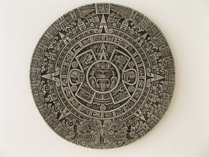 The Aztec Sun Stone, a detailed circular stone carving from the Aztec Empire showing symbols of time, the universe and Aztec gods